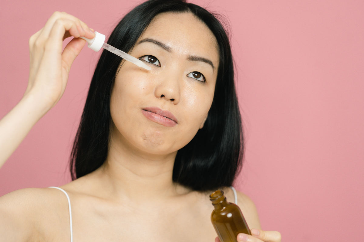 Aplicação de um cuidado facial com conta-gotas.